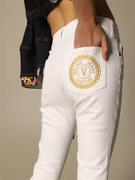 white versace pants with logo running down side|Versace pantsuit.